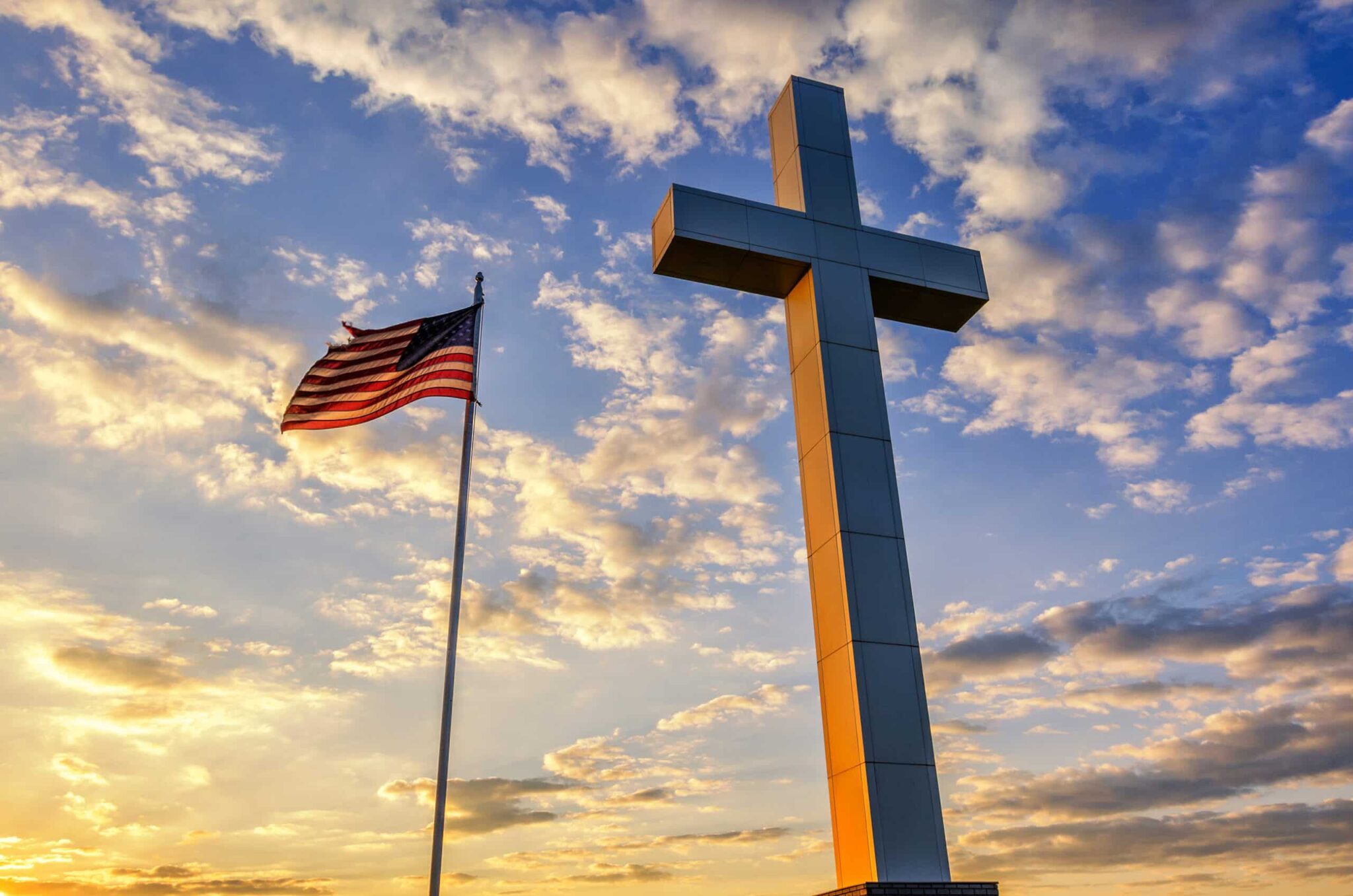 American,Flag,And,Religious,Cross,At,Sunset