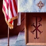 brown wooden cross with flag of us a on top