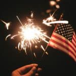 time lapse photography of sparkler and U.S.A flag let