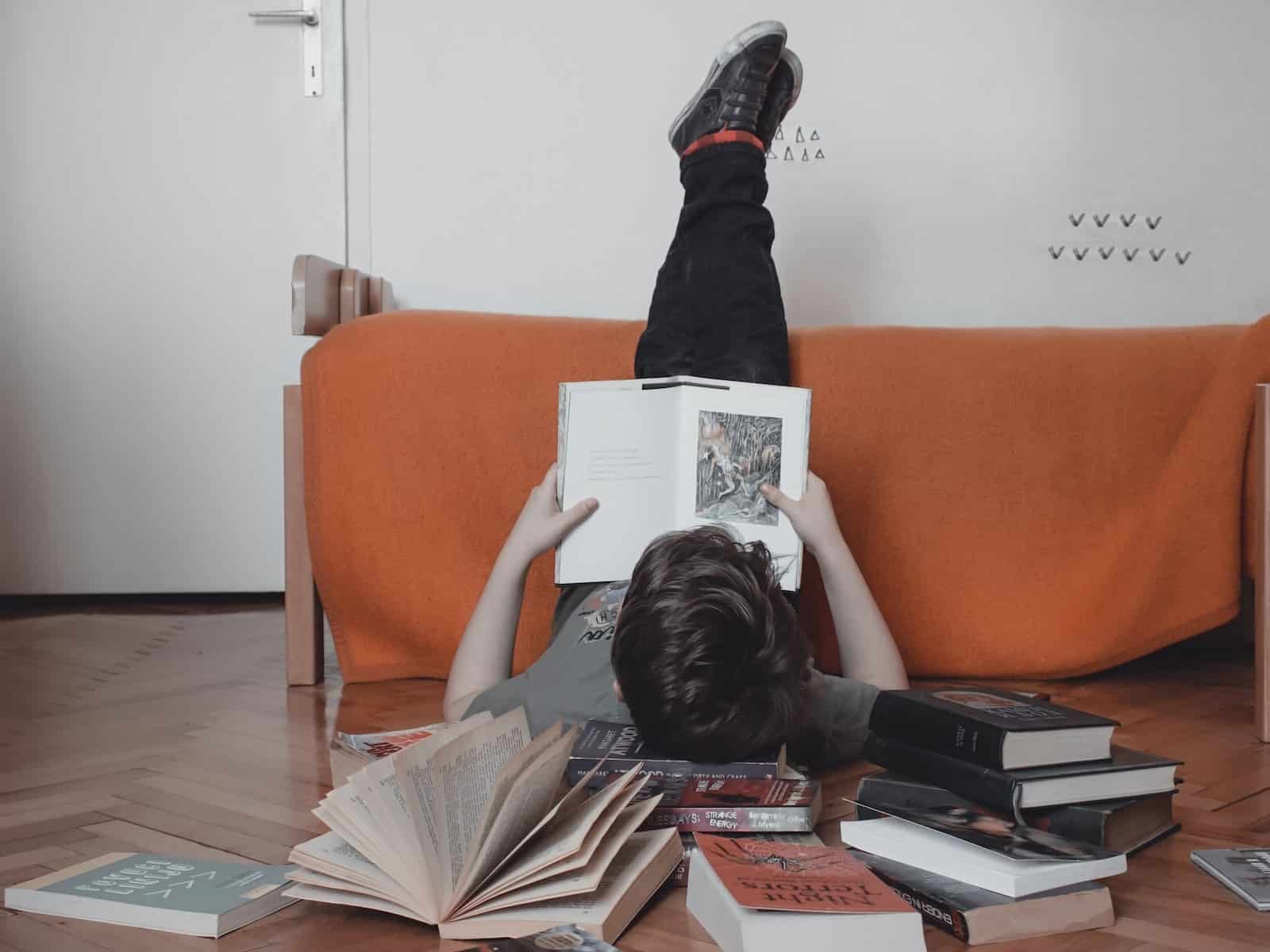 woman reading book on orange sofa