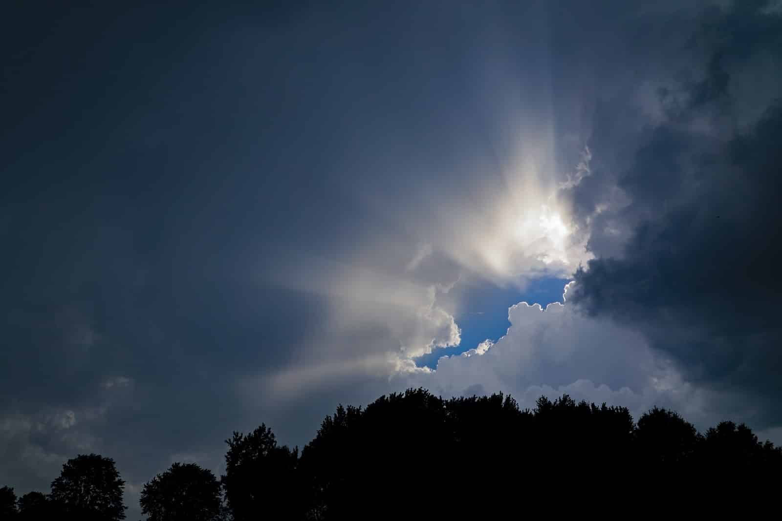 low angle photography of sun covering by clouds