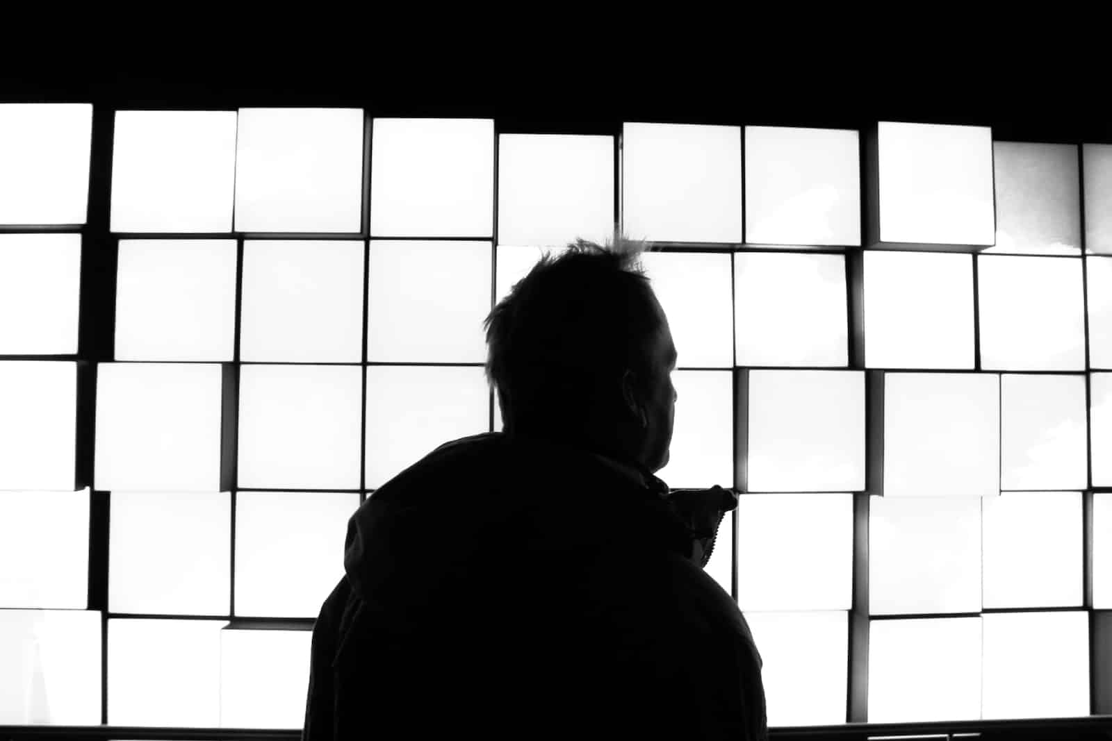 silhouette of man standing near window